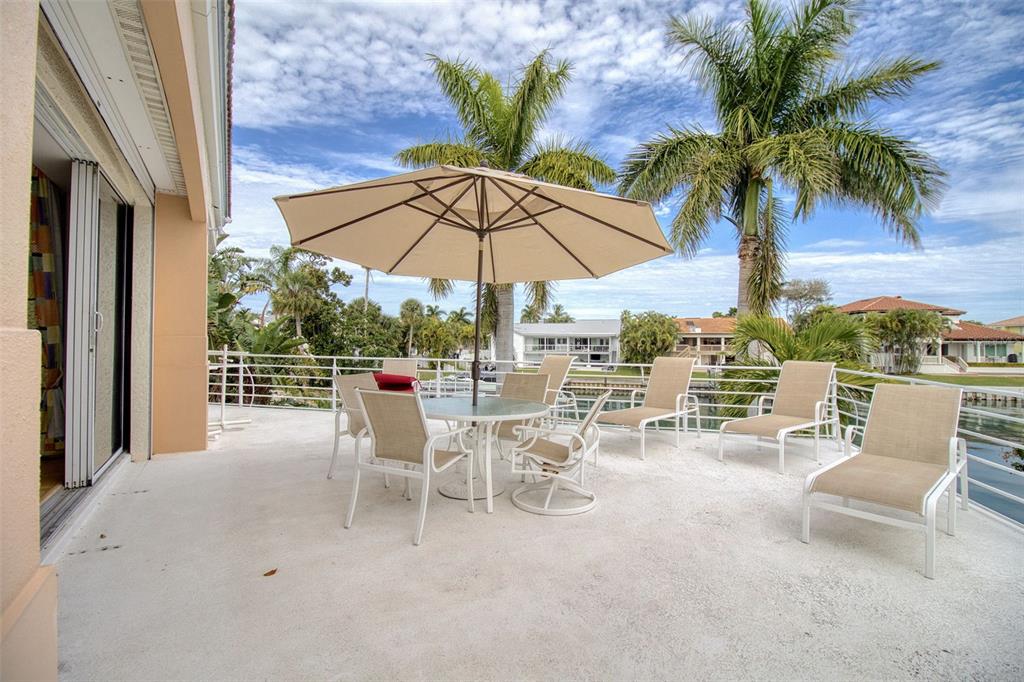 131 13th Street East Tierra Verde, FL 33715 - Photo 25 of 54 a view of a patio with a table and chairs under an umbrella