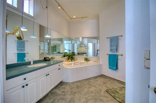 a bathroom with a tub a double vanity sink and a mirror