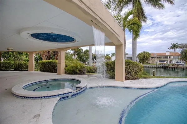 front view of a house with a yard and palm trees