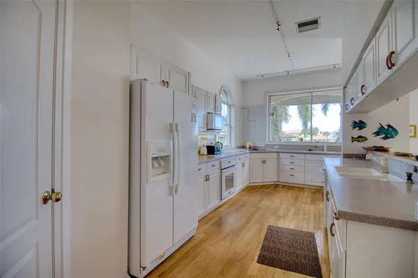 a kitchen with white cabinets and refrigerator
