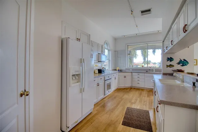 a kitchen with white cabinets and refrigerator
