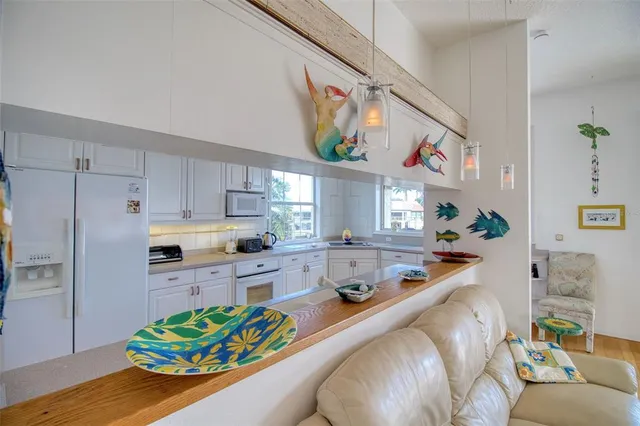 a kitchen with stainless steel appliances kitchen island granite countertop a refrigerator and a stove top oven