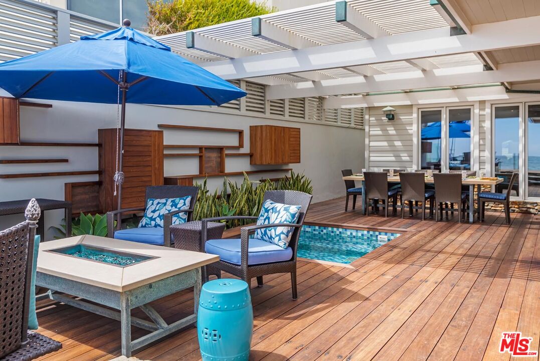 23416 Malibu Colony Road Malibu, CA 90265 - Photo 23 of 26 a view of a patio with table and chairs under an umbrella