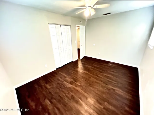 en empty room with window and ceiling fan