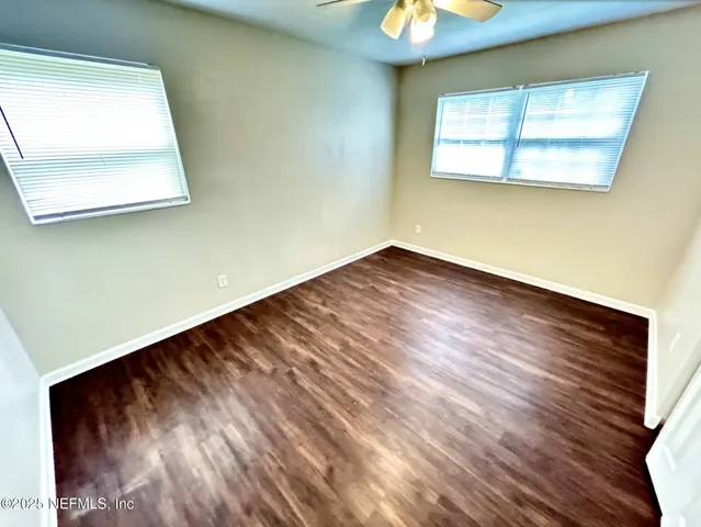 a view of a room that has wooden floor and a window