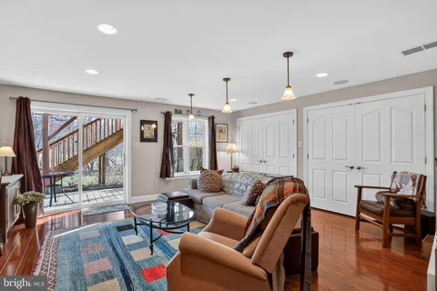 a living room with furniture a large window and wooden floor