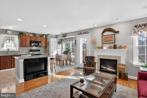 a living room with furniture a fireplace and kitchen view
