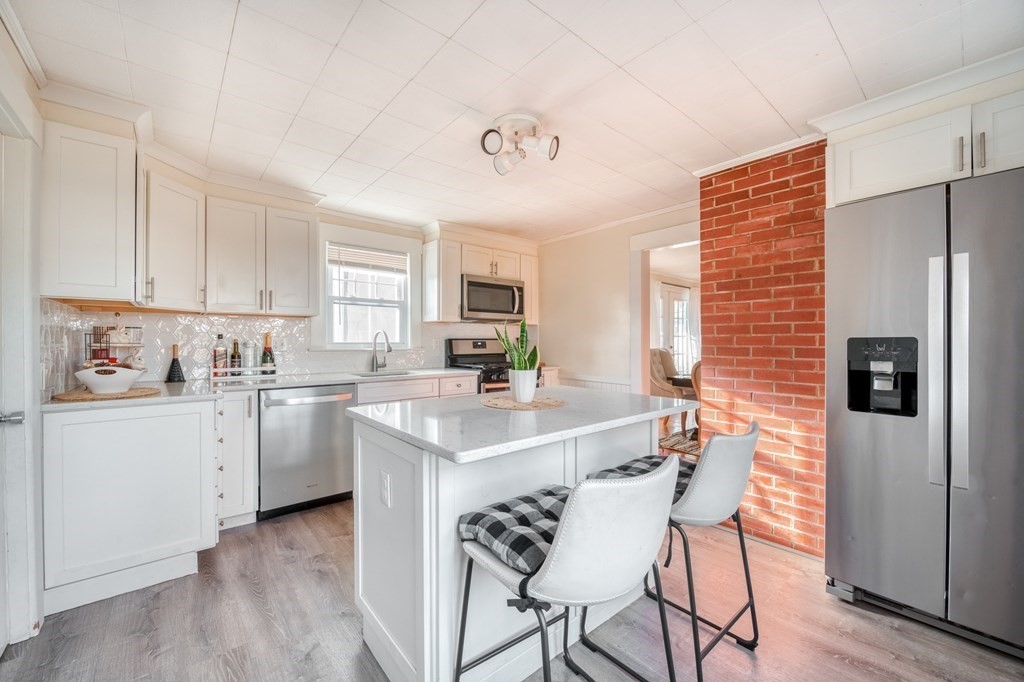 a kitchen with granite countertop white cabinets and stainless steel appliances