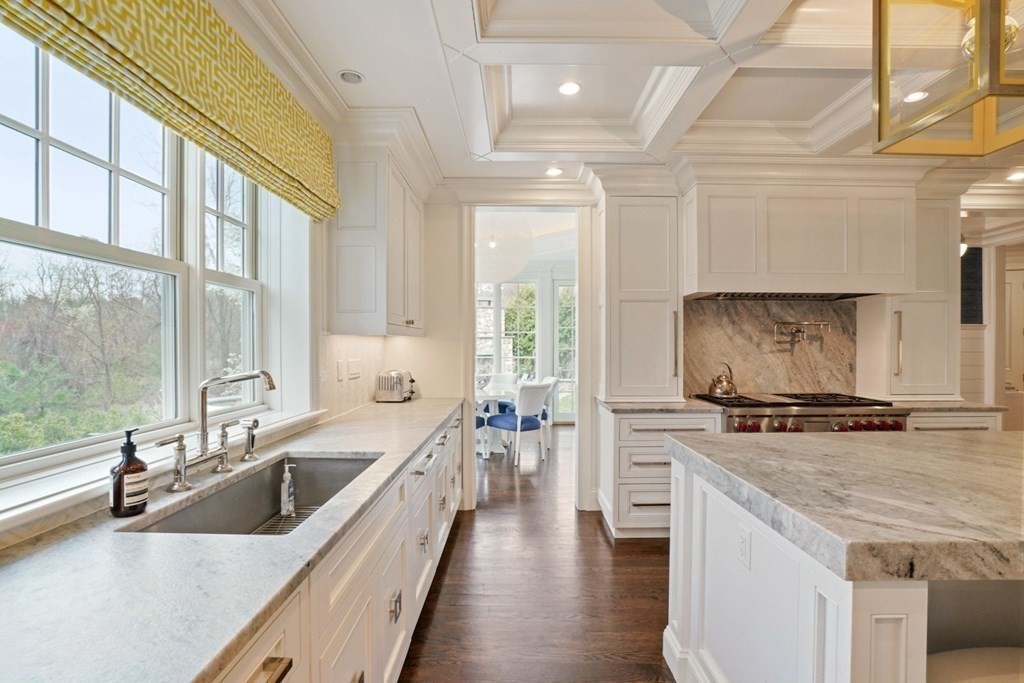 64 Cartwright Road Needham, MA 02492 - Photo 12 of 40 a kitchen with a stove a sink and white cabinets with wooden floor