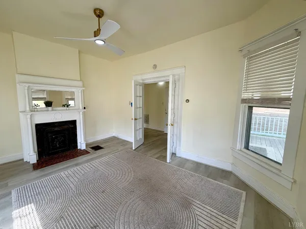 a view of an empty room with a fireplace and a window