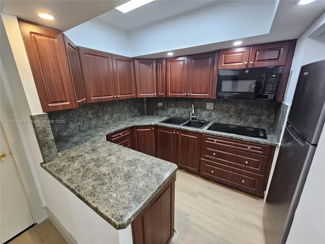 a kitchen with stainless steel appliances granite countertop a refrigerator and a sink