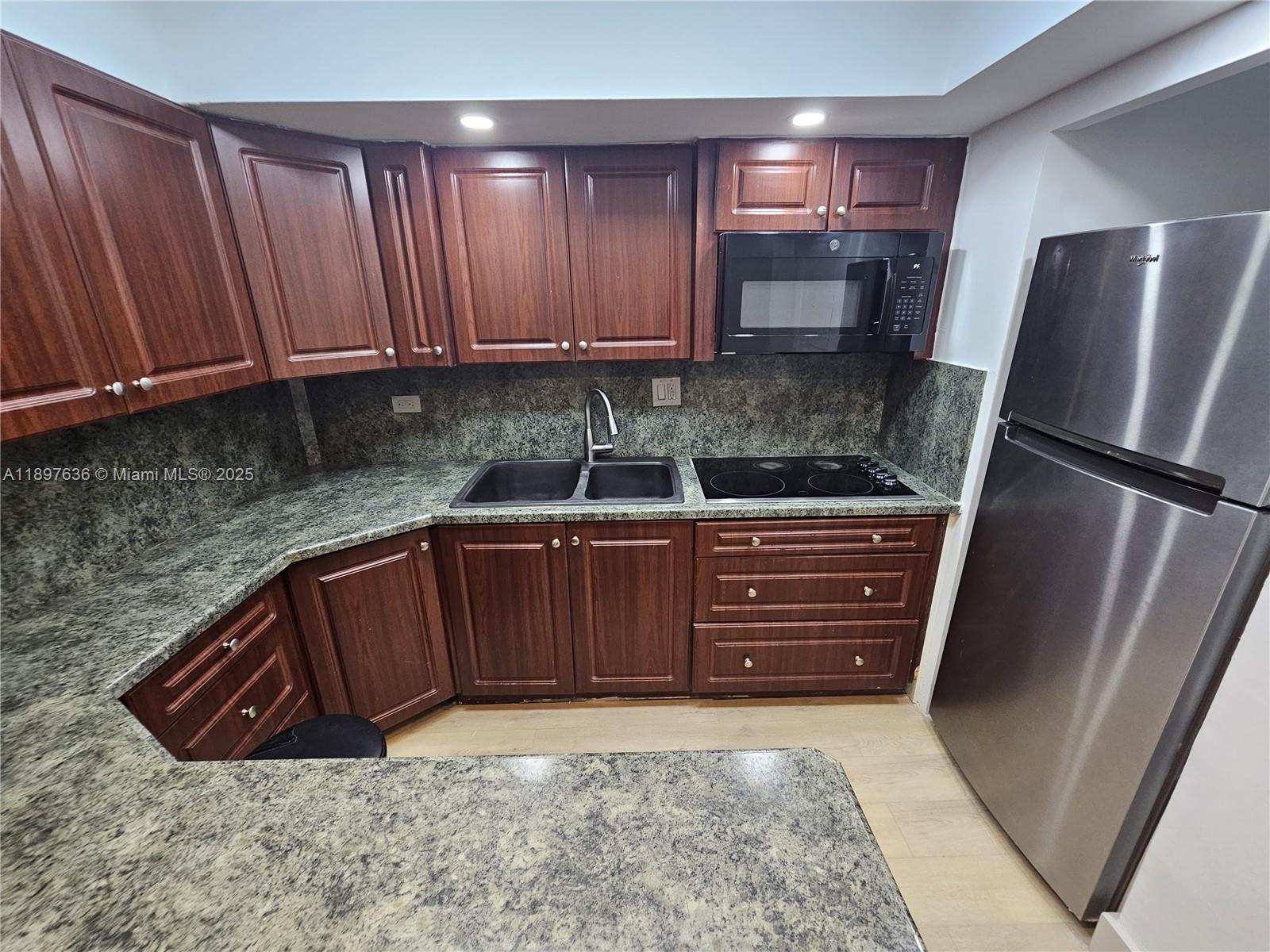 1408 Brickell Bay Drive, Unit 316 Miami, FL 33131 - Photo 13 of 19 a kitchen with stainless steel appliances granite countertop a refrigerator and a sink