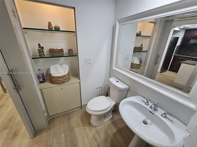 a bathroom with a toilet sink and mirror