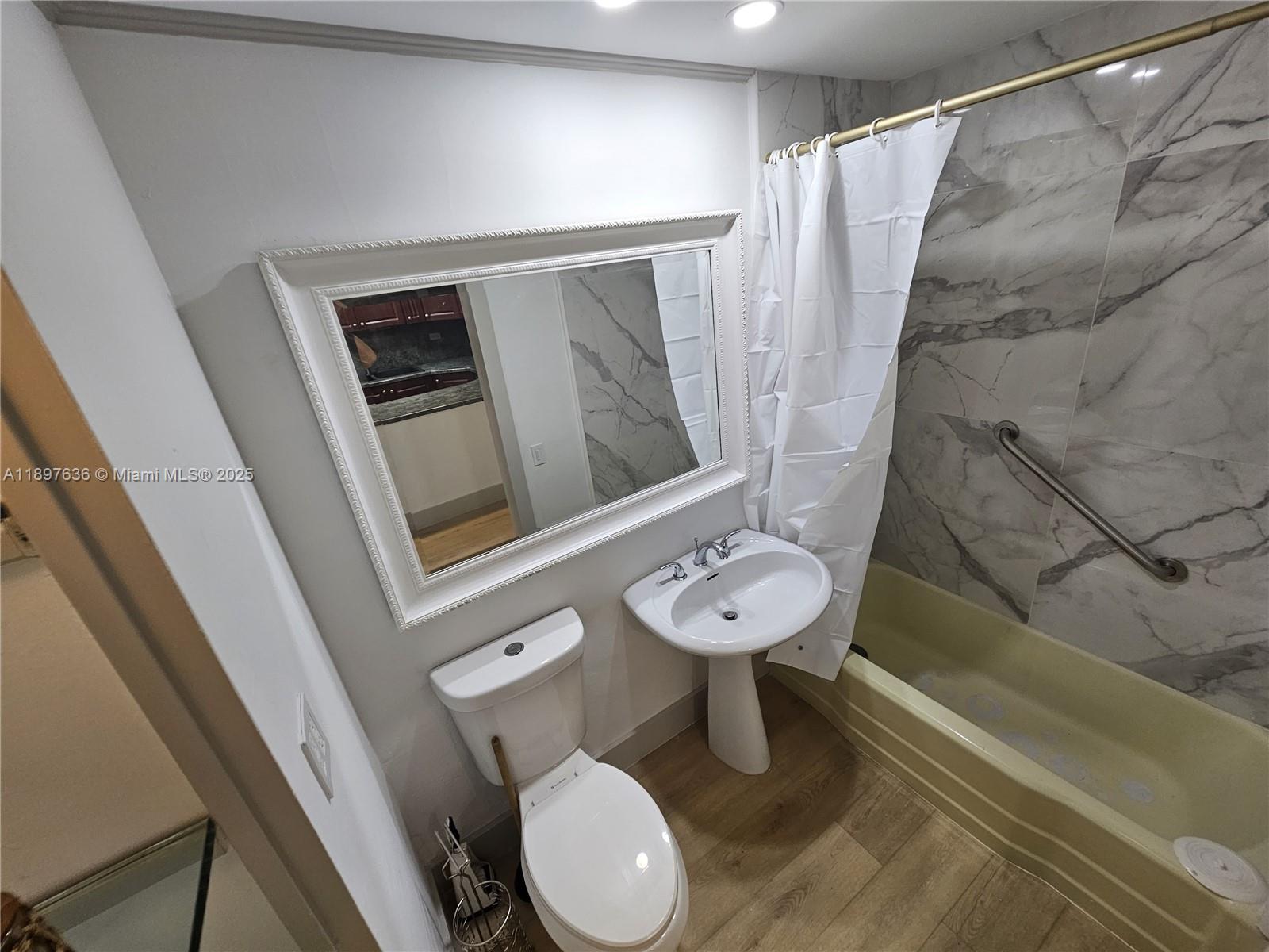 1408 Brickell Bay Drive, Unit 316 Miami, FL 33131 - Photo 16 of 19 a bathroom with a toilet sink and mirror