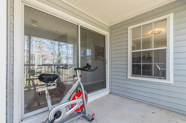 an empty room with wooden floor fireplace and windows