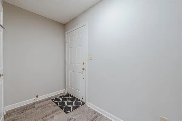 an empty room with wooden floor chandelier fan and windows