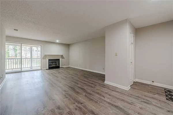 an empty room with wooden floor chandelier fan and closet
