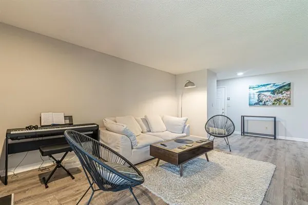 a living room with furniture a rug and a table
