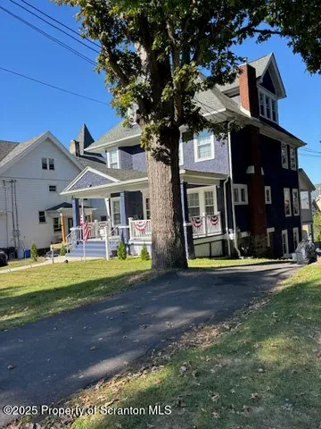 a view of a brick house with a yard