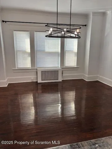 a view of a room with wooden floor window and kitchen view