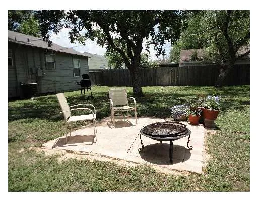 a view of a backyard with furniture and a fire pit