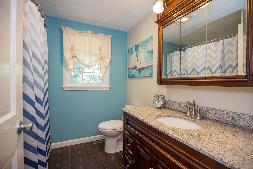 19 Gov Doherty Road Billerica, MA 01821 - Photo 22 of 28 a bathroom with a granite countertop toilet sink and mirror