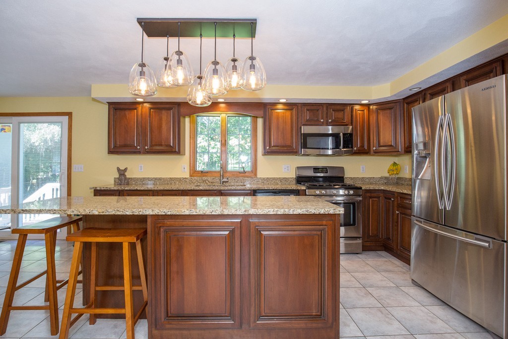 19 Gov Doherty Road Billerica, MA 01821 - Photo 6 of 28 a kitchen with granite countertop wooden cabinets and a stainless steel appliances