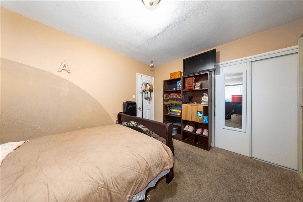 566 South Sage Avenue Rialto, CA 92376 - Photo 19 of 28 a bedroom with a bed and a large mirror