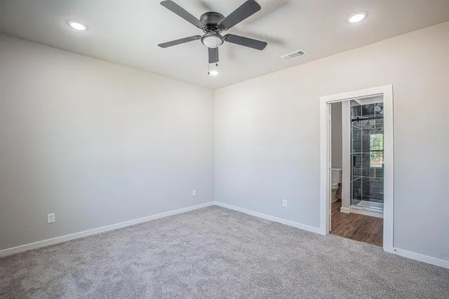 an empty room with a ceiling fan and window