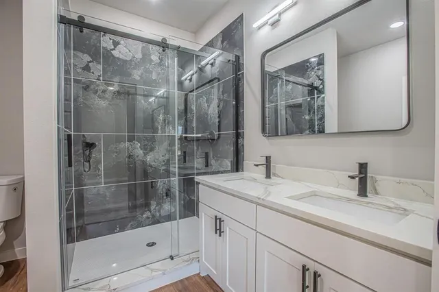 a bathroom with a shower sink and mirror