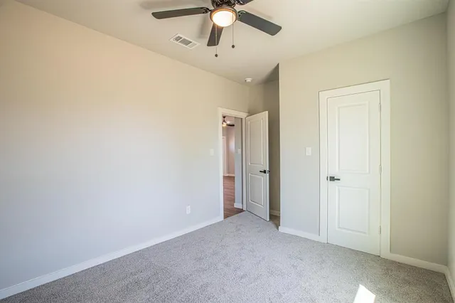 an empty room with fan and entrance