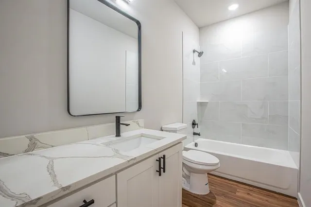 a bathroom with a granite countertop sink toilet a large mirror and shower