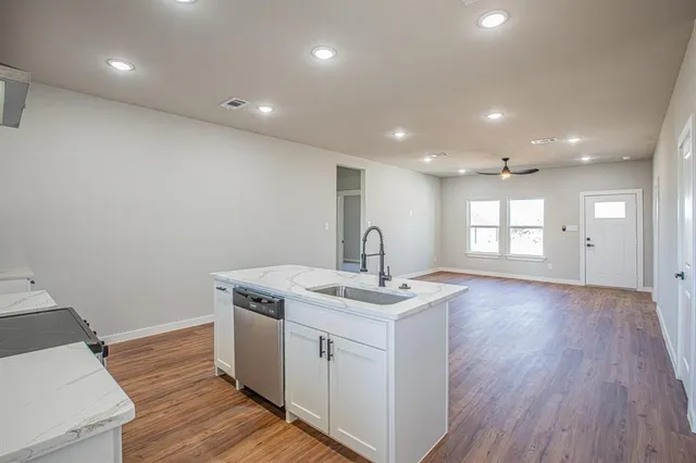 a view of a kitchen with a sink wooden floor and a window