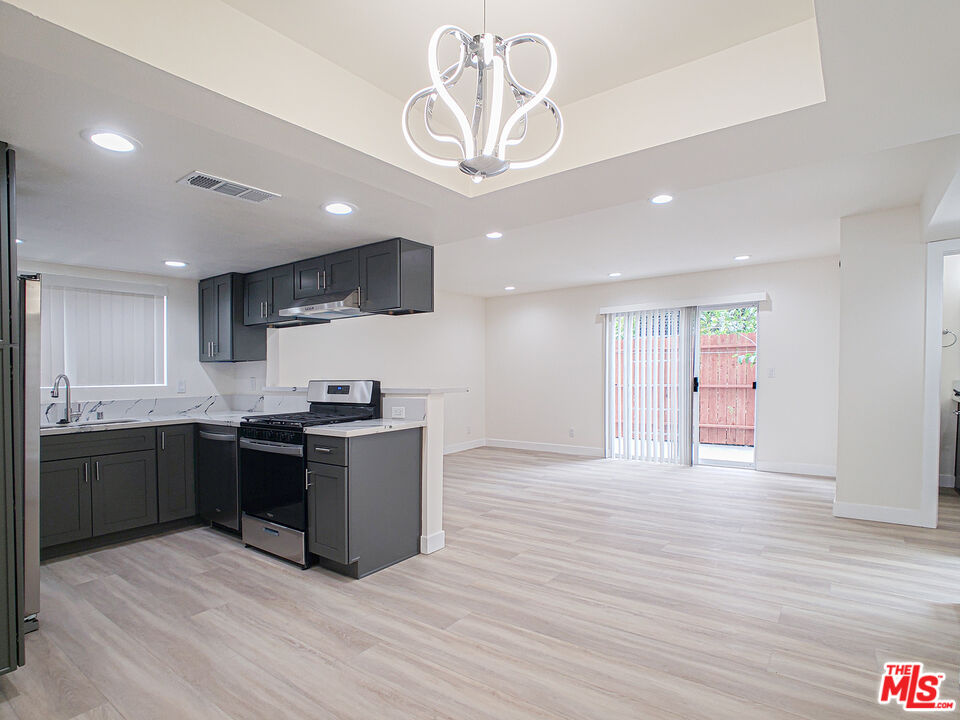a large kitchen with stainless steel appliances granite countertop a stove and a sink