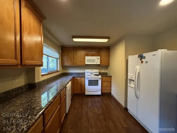 a kitchen with stainless steel appliances granite countertop a refrigerator a stove and a wooden floors