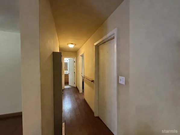 a view of a hallway with wooden floor