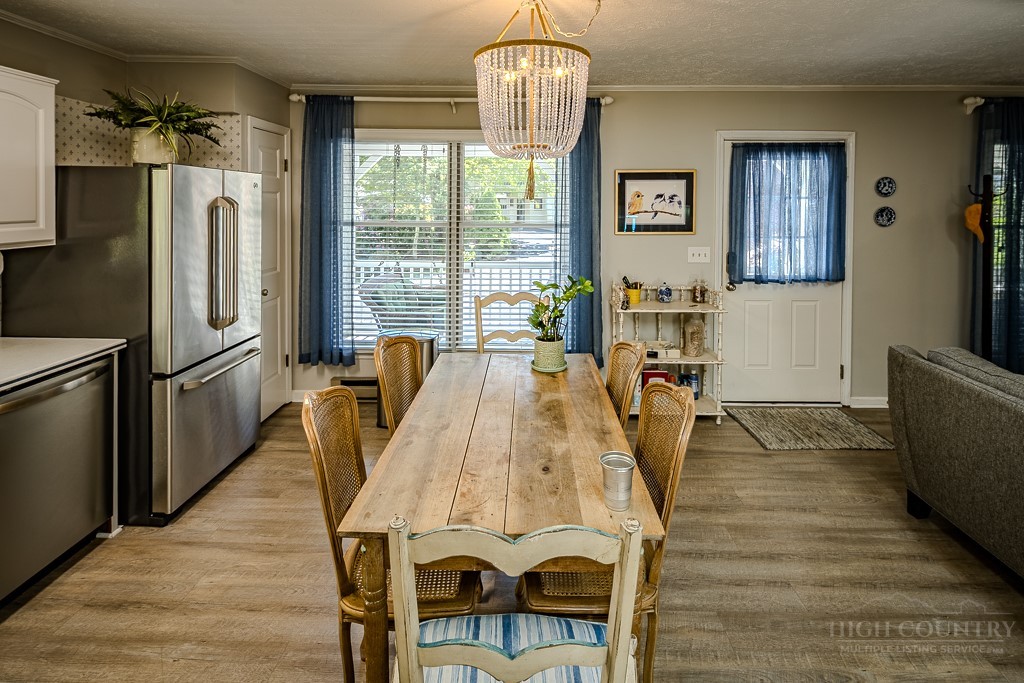 38 Rocky Meadows Road Newland, NC 28657 - Photo 10 of 50 a view of a dining room with furniture a chandelier and wooden floor