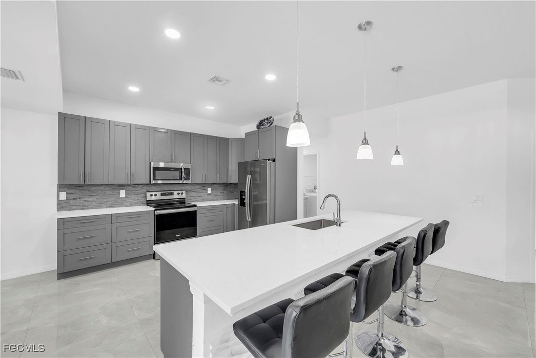 7881 Buckingham Road Fort Myers, FL 33905 - Photo 12 of 49 a kitchen with stainless steel appliances a sink stove and refrigerator