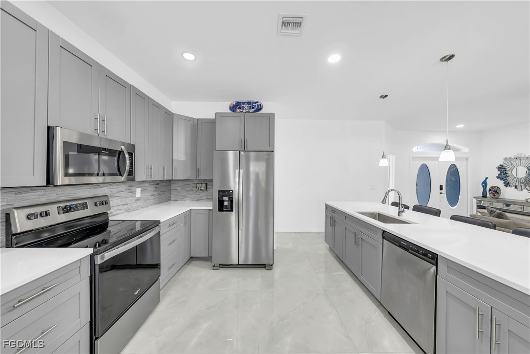 7881 Buckingham Road Fort Myers, FL 33905 - Photo 15 of 49 a kitchen with stainless steel appliances granite countertop a sink stove and refrigerator
