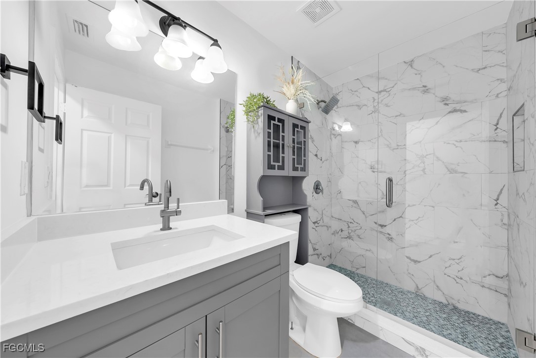 7881 Buckingham Road Fort Myers, FL 33905 - Photo 18 of 49 a bathroom with a sink a toilet a mirror and shower