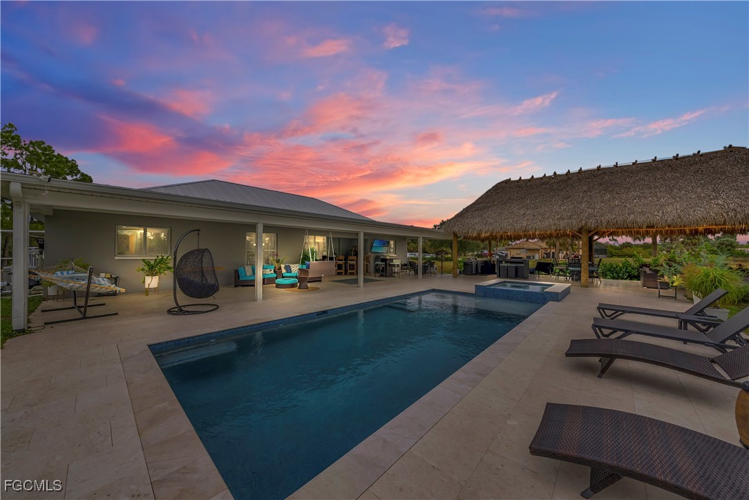 7881 Buckingham Road Fort Myers, FL 33905 - Photo 2 of 49 a view of a patio with couches and table and chairs under an umbrella