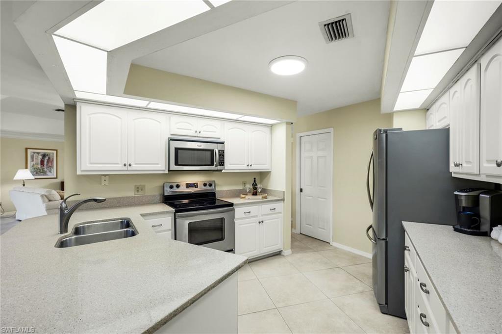 2383 Mayfield Court, Unit 4 Naples, FL 34105 - Photo 5 of 21 a kitchen with stainless steel appliances granite countertop a sink stove and refrigerator