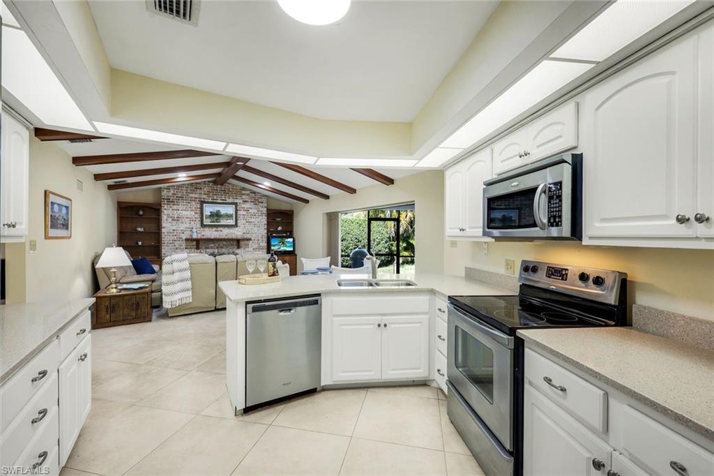 2383 Mayfield Court, Unit 4 Naples, FL 34105 - Photo 6 of 21 a kitchen with stainless steel appliances granite countertop a sink and cabinets