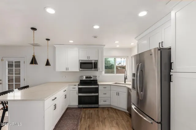 a kitchen with stainless steel appliances a refrigerator sink and stove