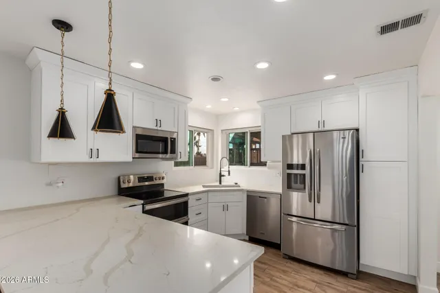 a kitchen with stainless steel appliances a refrigerator sink and microwave