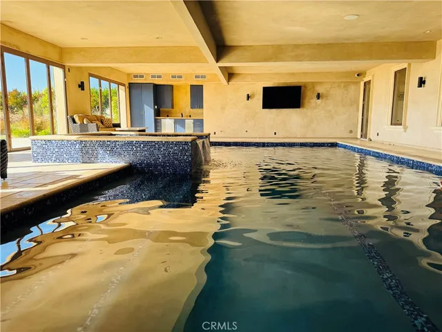 a swimming pool with large glass windows and painted walls