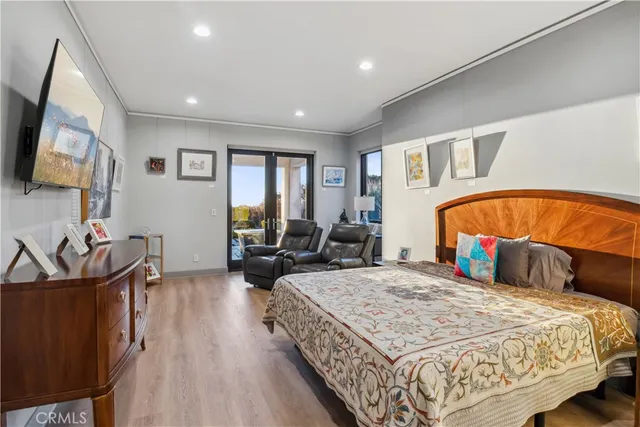 a bathroom with a glass shower door and a wooden floor
