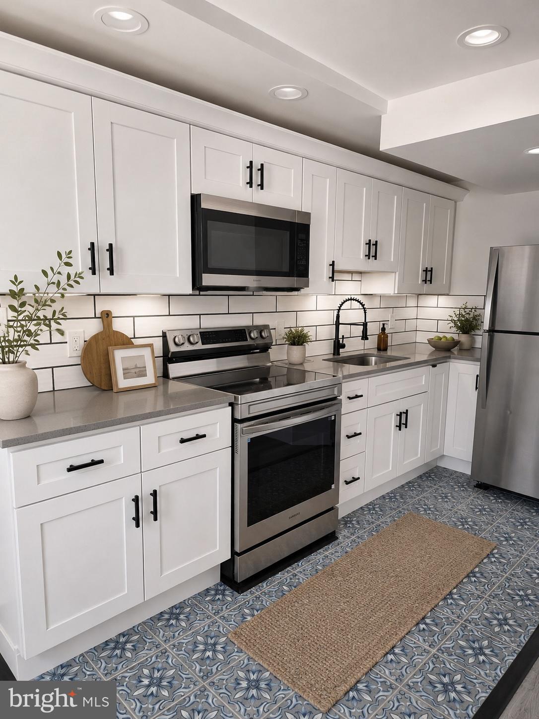 5925 Ridge Avenue, Unit 5 Philadelphia, PA 19128 - Photo 3 of 31 a kitchen with stainless steel appliances granite countertop a sink a stove a microwave and cabinets