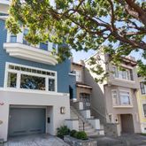 a front view of a house with a tree