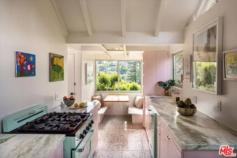 a kitchen with stainless steel appliances a stove a sink a refrigerator and a wooden cabinets